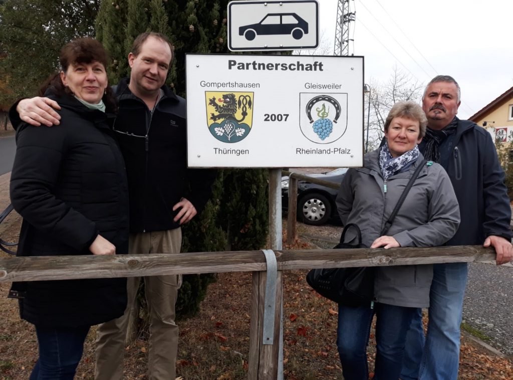 Botschafter aus Gompertshausen vor dem Schild der Ortspartnerschaft.